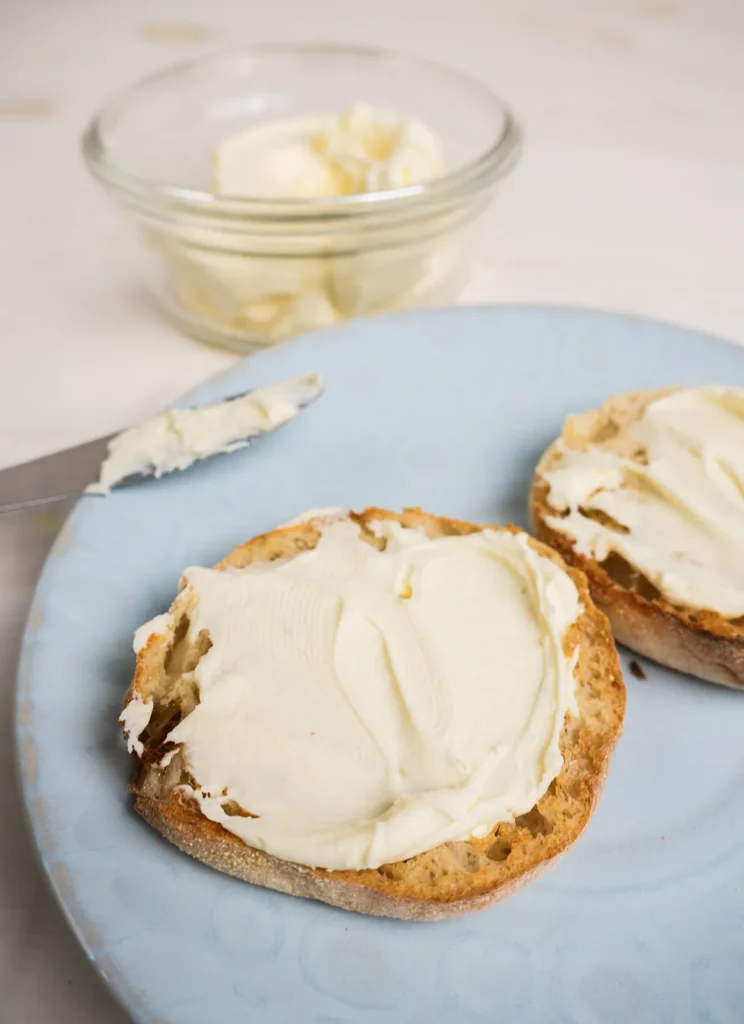 Homemade mascarpone cheese spread on an english muffin.