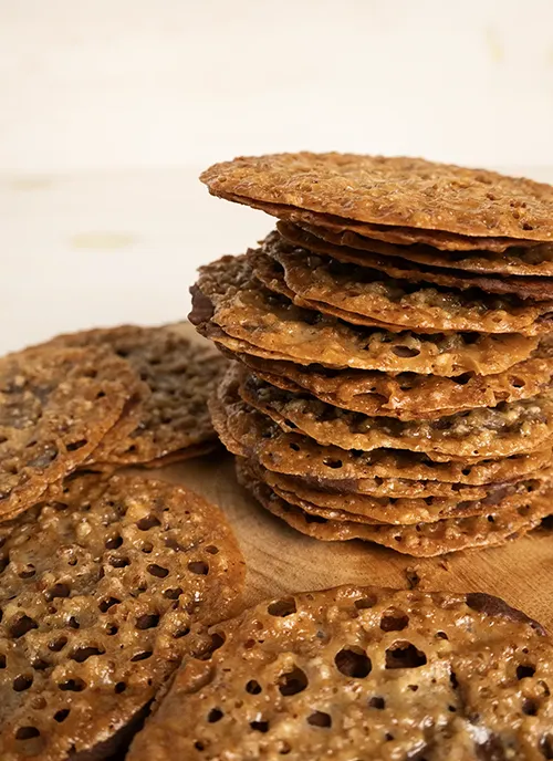 Tray with a stack of pecan florentine cookies sandwiched with chocolate.
