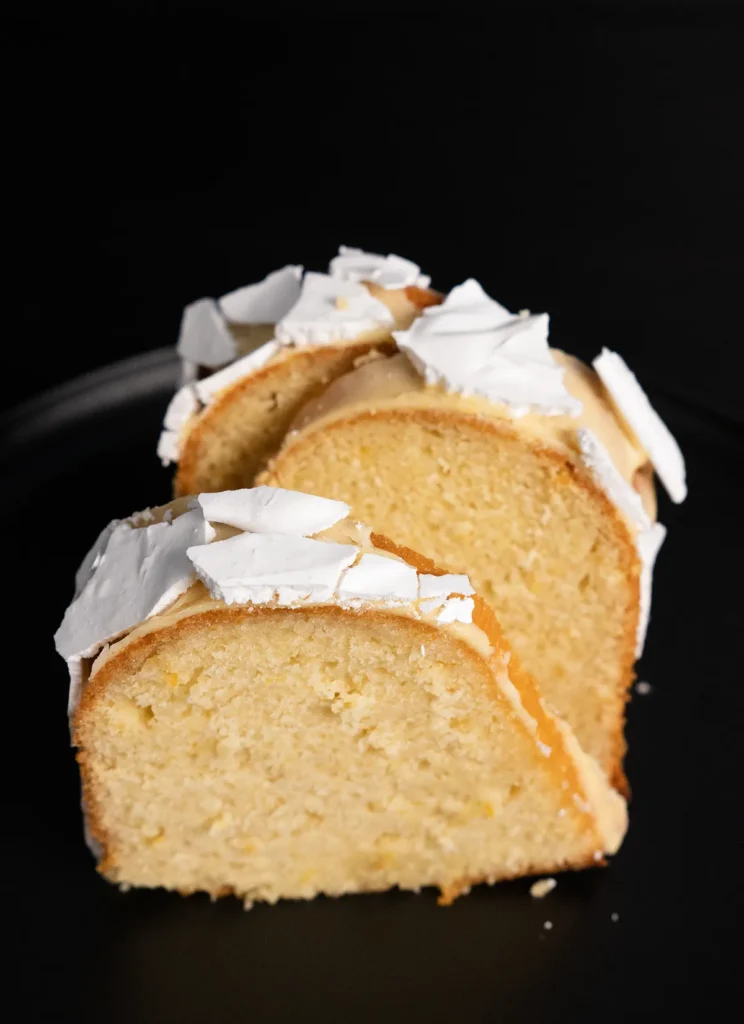 Slices of gourmet lemon bundt cake with preserved lemon and meringue shards.