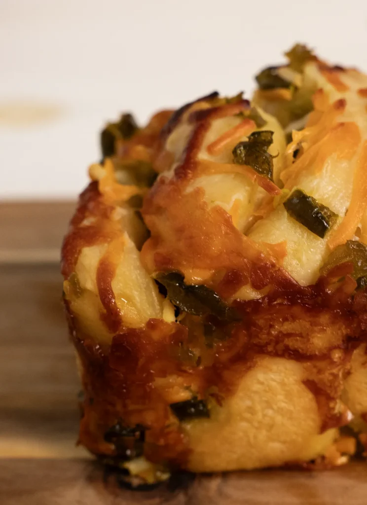Jalapeño Cheddar Pull Apart Loaf on a wooden cutting board.
